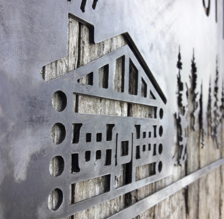 This sign is displays a mountain range in the background with a forest and cabin. The sign reads, "INNISFREE".
