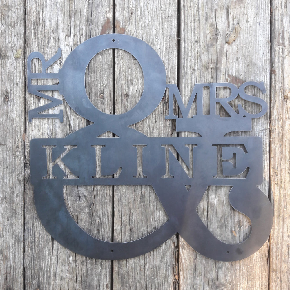 Personalized metal sign in the shape of an ampersand. The sign reads, "Mr. & Mrs. Kline".