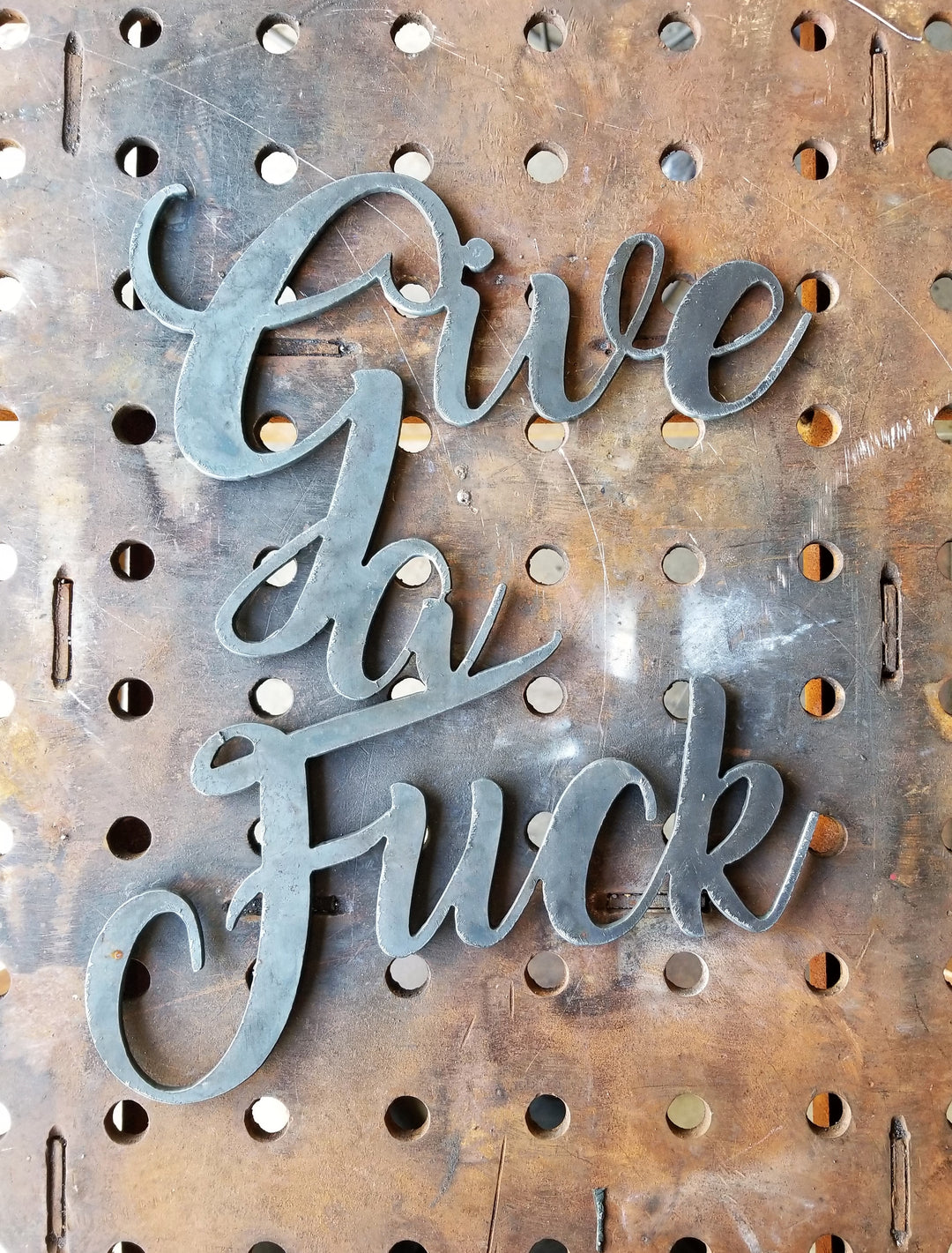 This is a personalized metal sign and reads, "Give a Fuck".