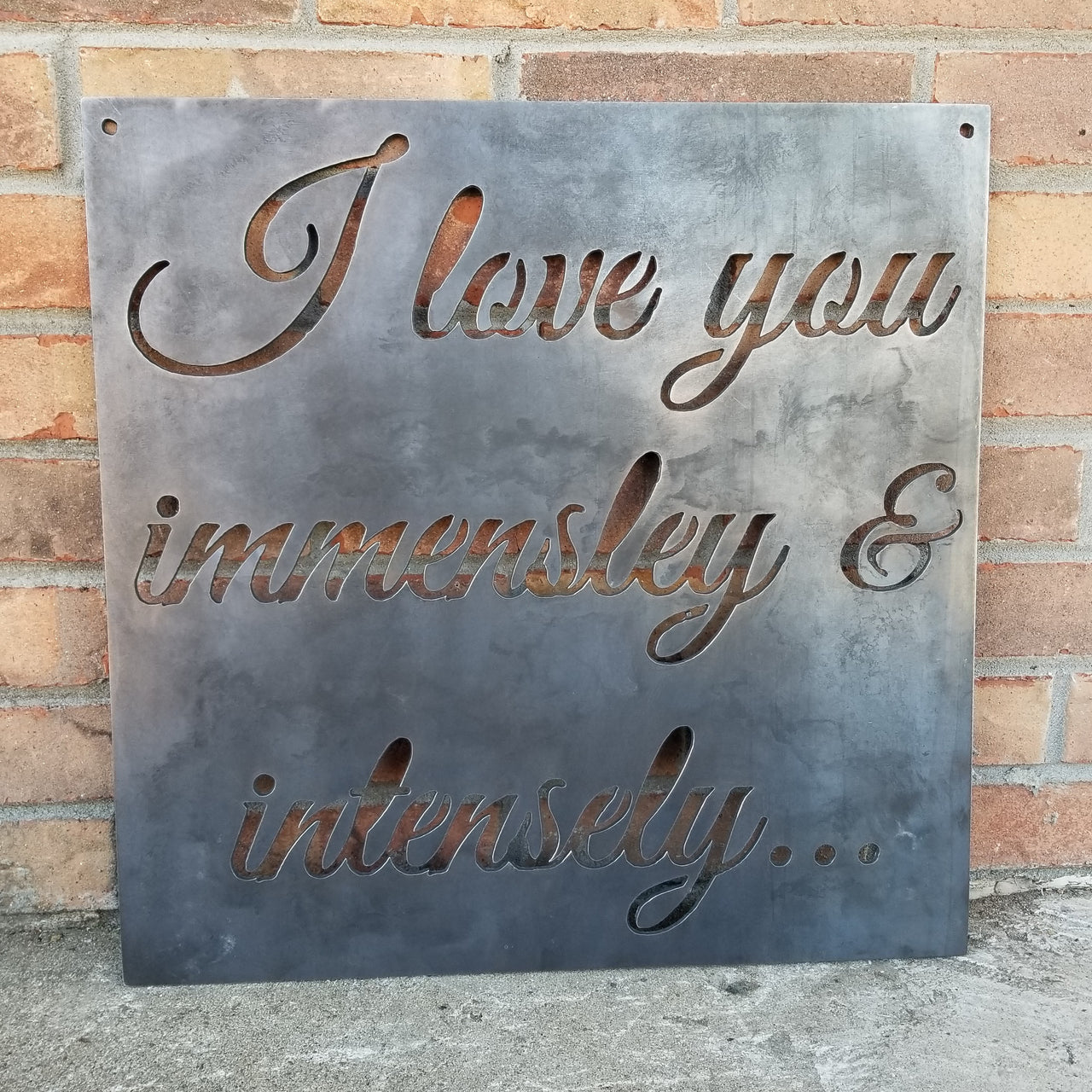 Square plaque with cursive writing in it. The sign reads, " I Love you immensely and intensely"