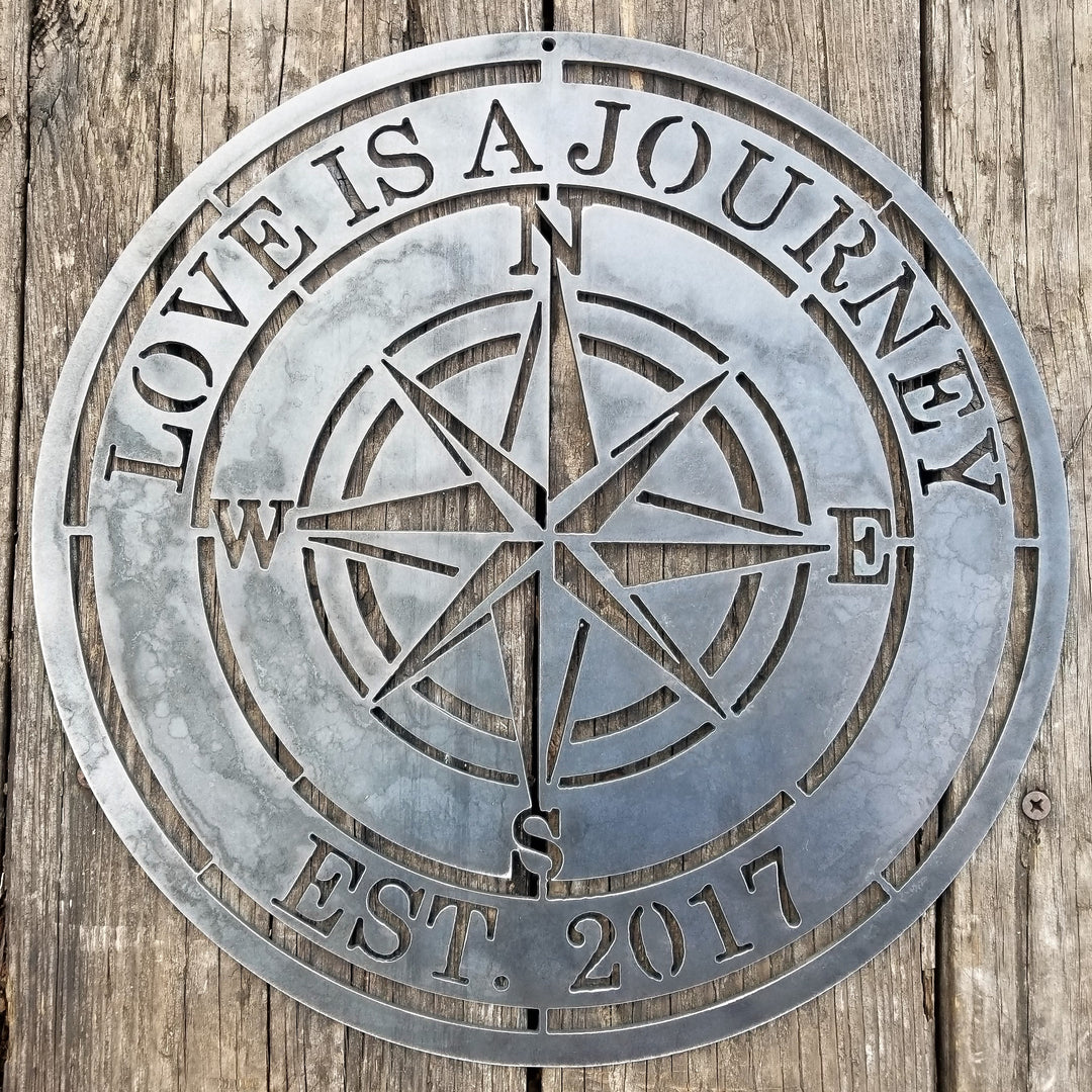 A nautical compass rose which reads, "Love is A Journey".
