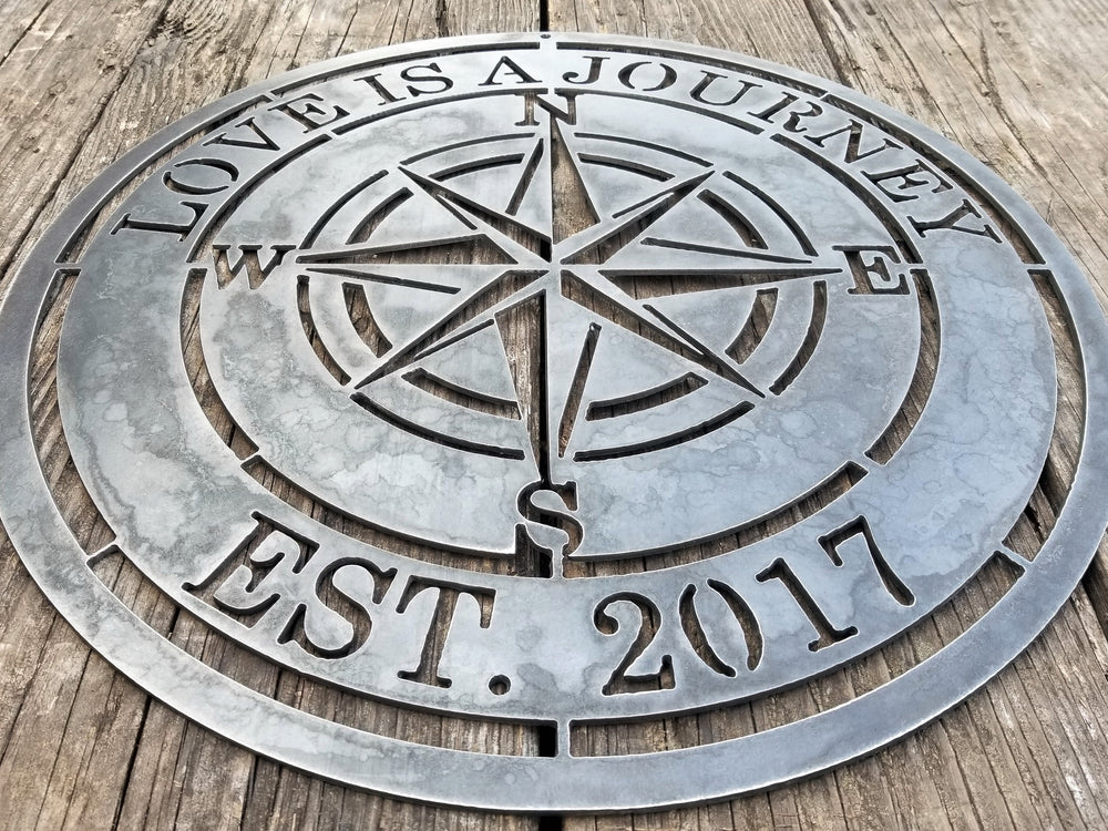A nautical compass rose which reads, "Love is A Journey".