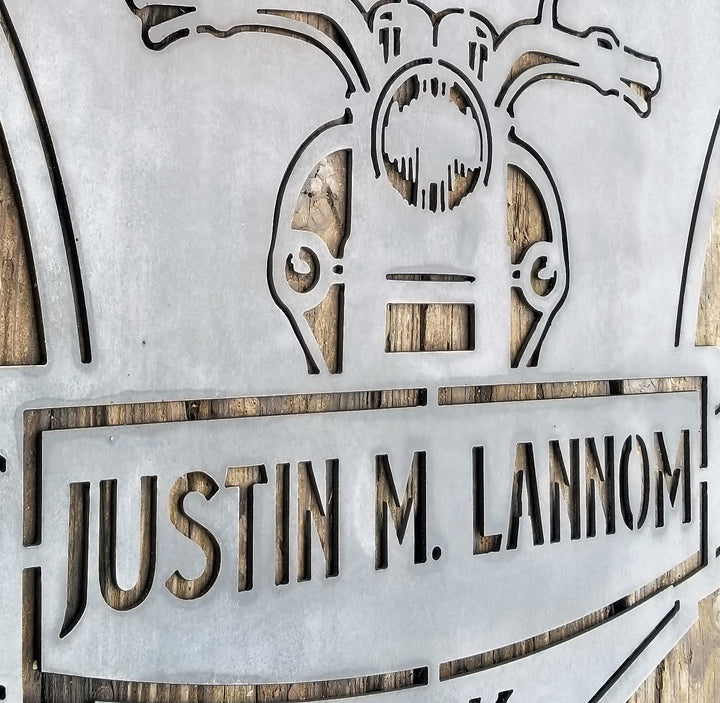 This is a memorial sign with an established year, dipicting an image of a motorcylce.  The bottom has a name and reads, "Justin M. Lannom".