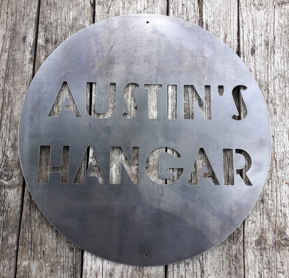 Round Personalized metal sign that reads, "Austin's Hangar"