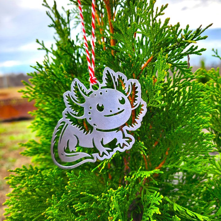 • cute axolotl metal ornament hanging on evergreen