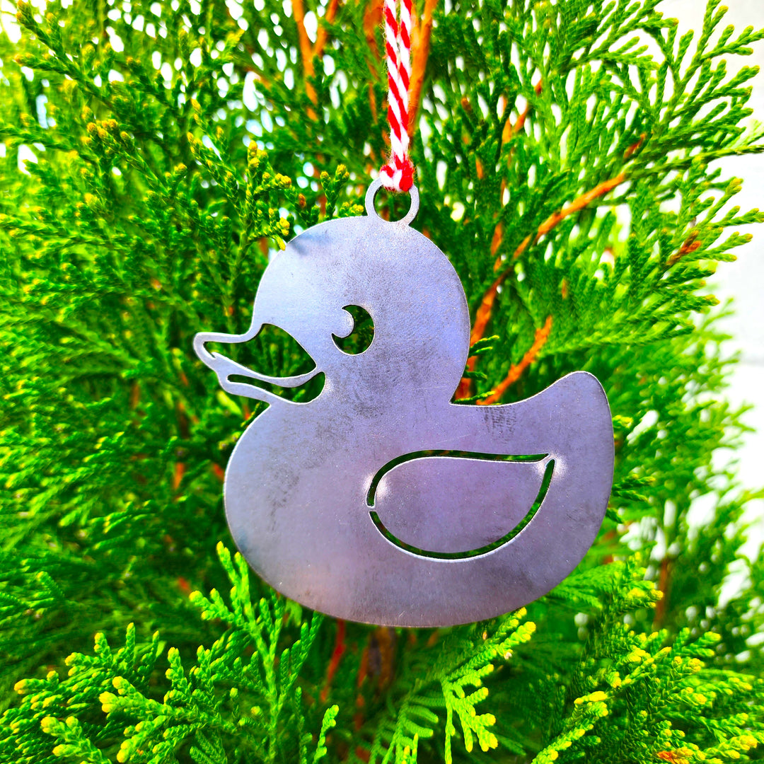 rubber duck metal ornament hanging on evergreen
