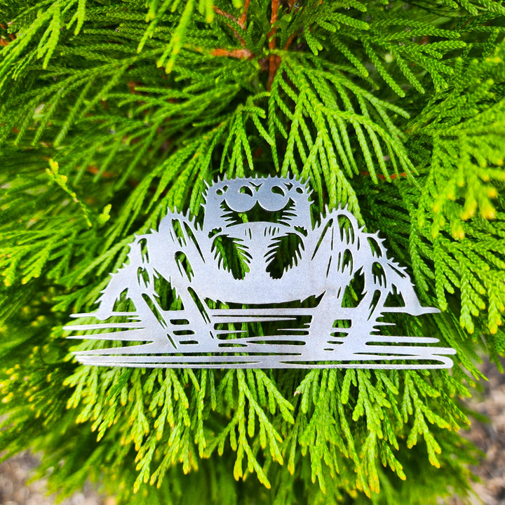 jumping spider metal ornament hanging on evergreen