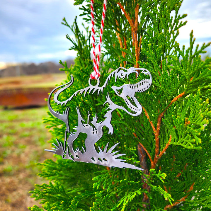 t-rex dinosaur metal ornament hanging on evergreen