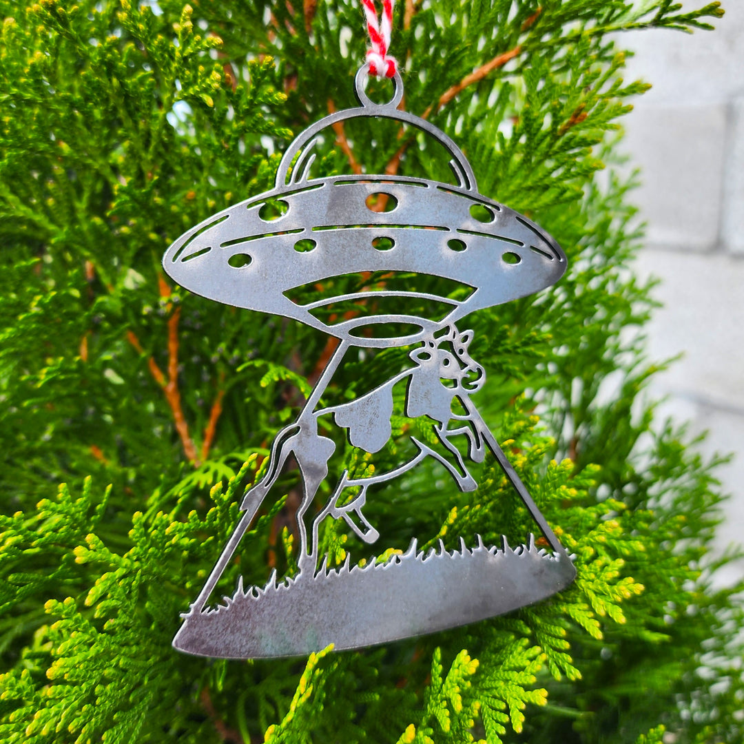 metal spaceship ornament beaming up a cow