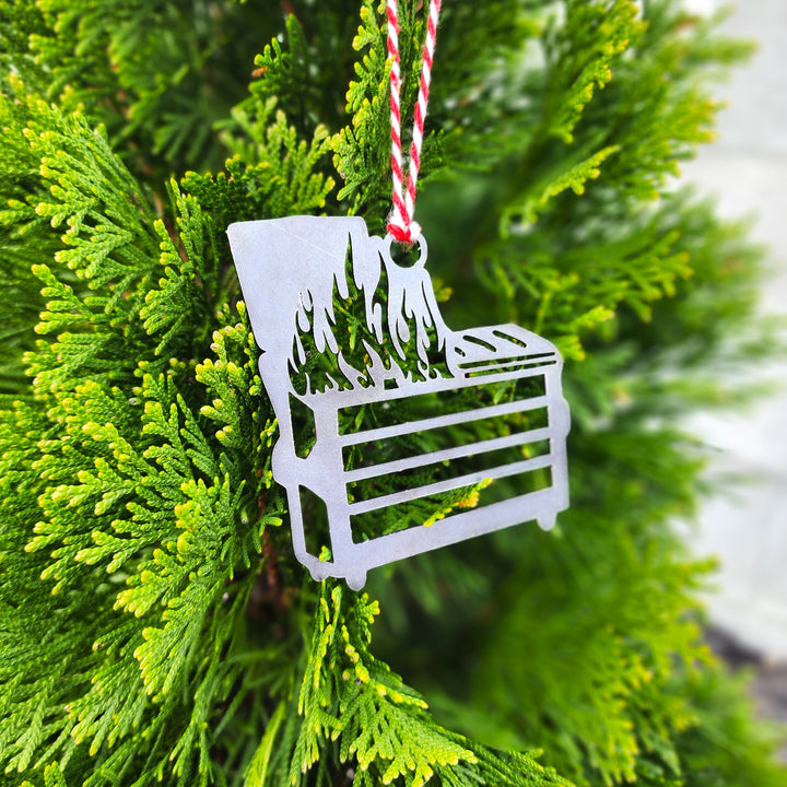 dumpster fire metal ornament hanging on evergreen