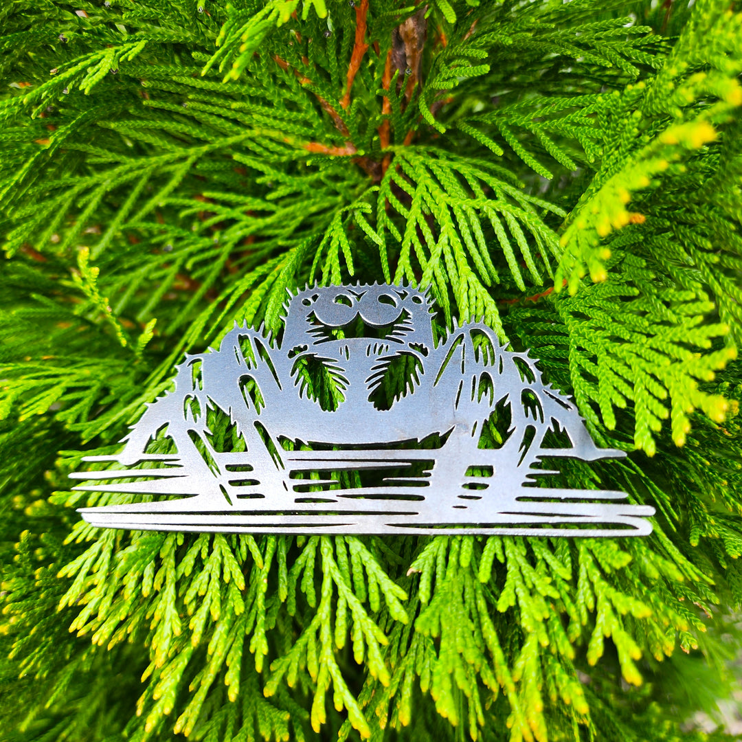 steel arachnid ornament on tree