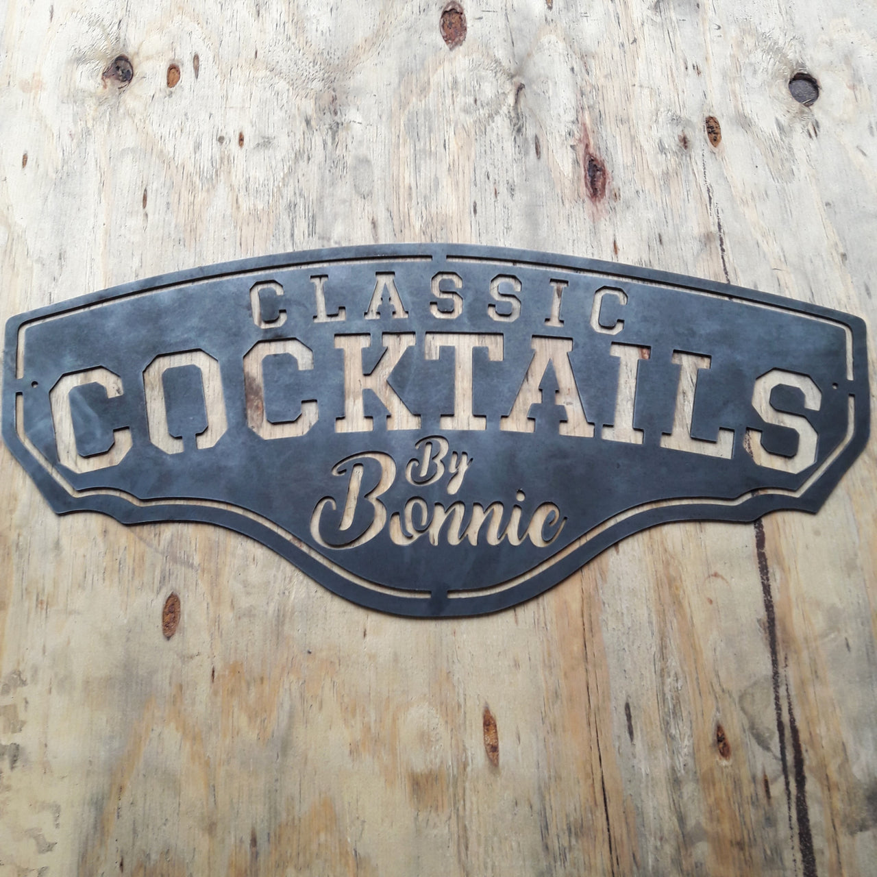 This metal bar sign reads, " Classic Cocktails By Bonnie"