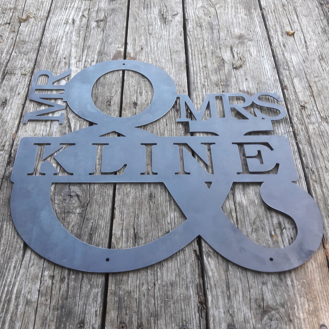 Personalized metal sign in the shape of an ampersand. The sign reads, "Mr. & Mrs. Kline".
