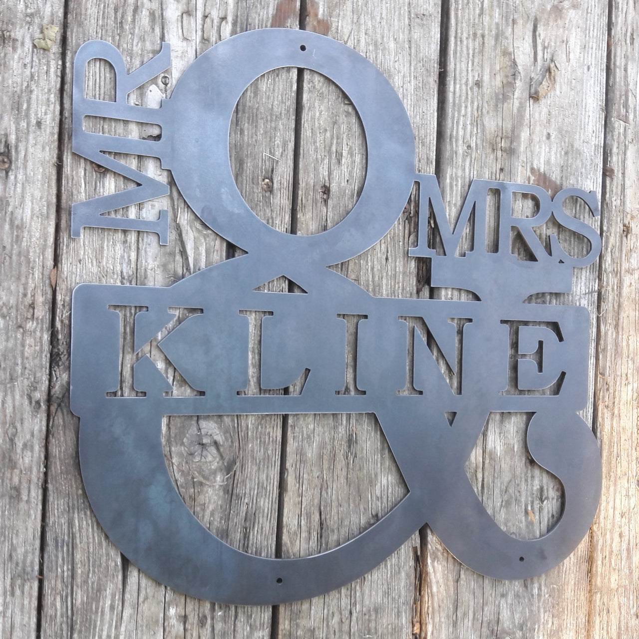 Personalized metal sign in the shape of an ampersand. The sign reads, "Mr. & Mrs. Kline".