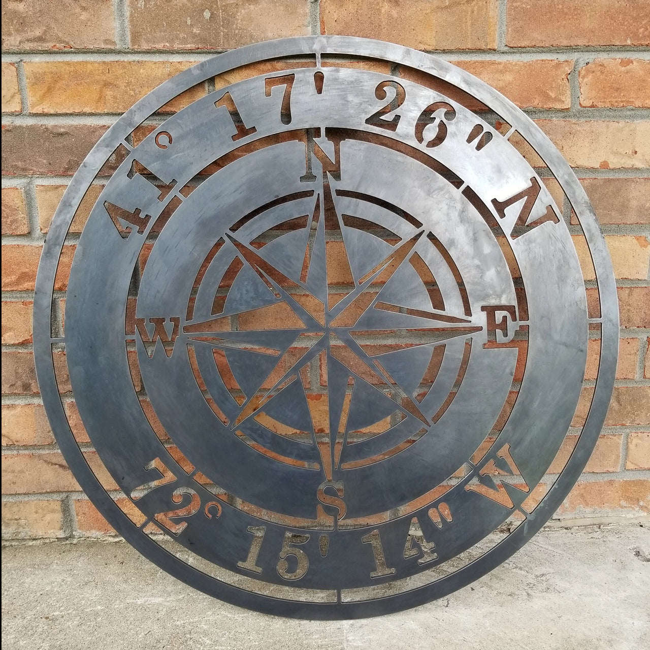 Metal Compass Rose With Coordinates. The coordinates read, "41 17 26 N 72 15 14 W"