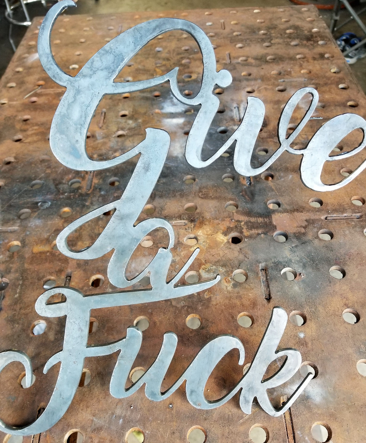 This is a personalized metal sign and reads, "Give a Fuck".