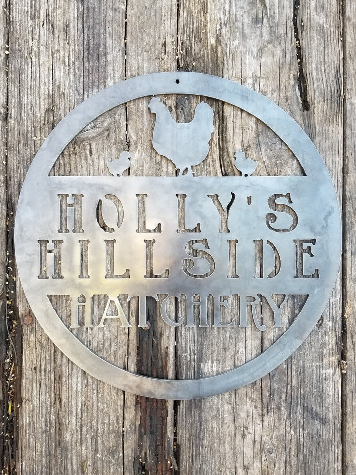 This metal sign is personalized and has the image of a chicken and two chicks at the top. The sign reads, "Holly's Hillside Hatchery".