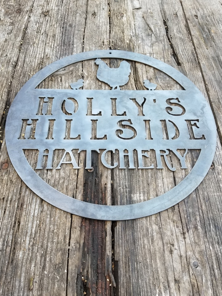 This metal sign is personalized and has the image of a chicken and two chicks at the top. The sign reads, "Holly's Hillside Hatchery".