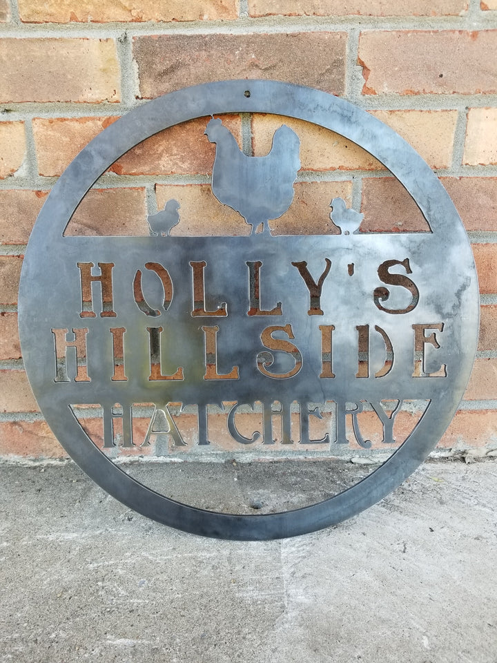 This metal sign is personalized and has the image of a chicken and two chicks at the top. The sign reads, "Holly's Hillside Hatchery".