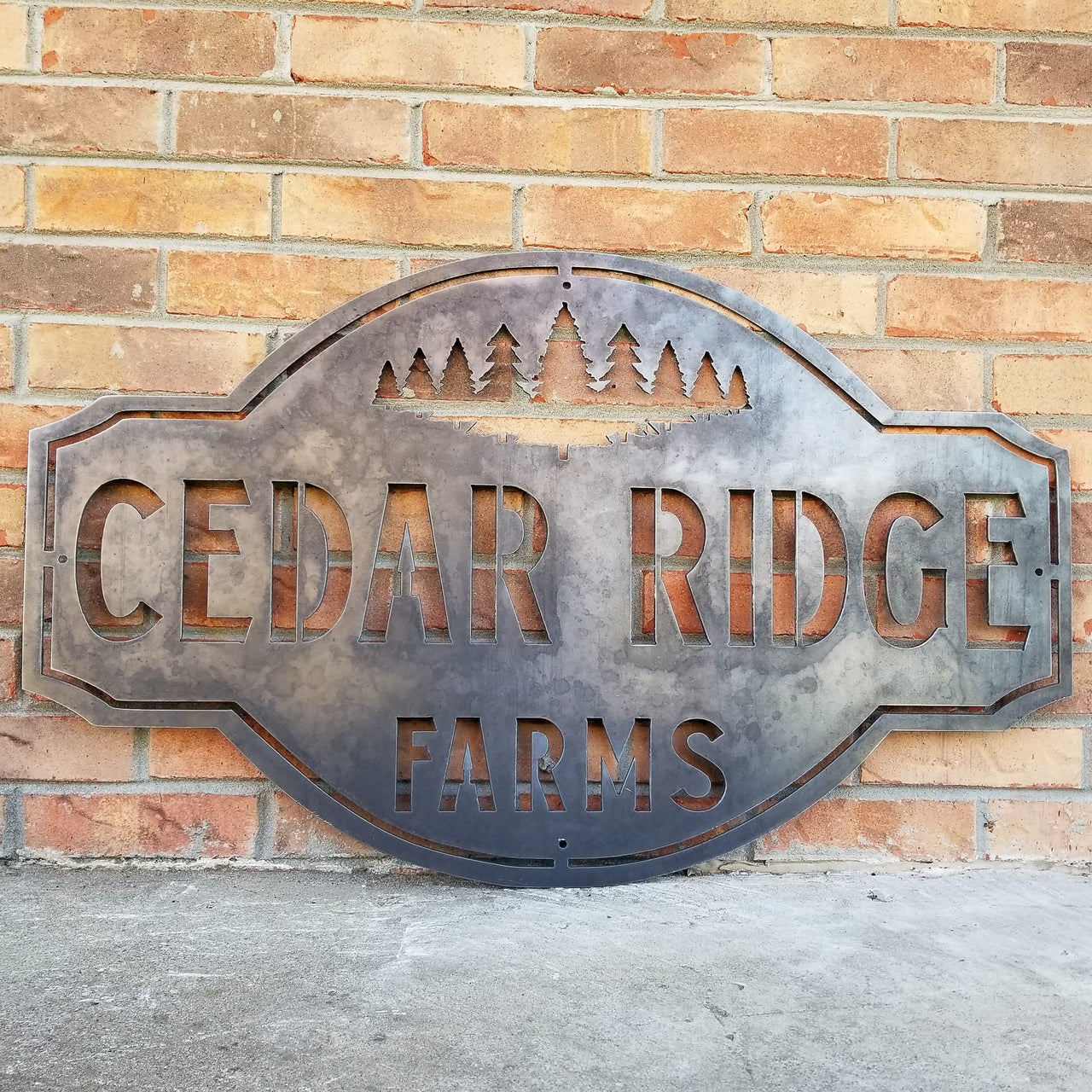 This is a rustic metal sign showcasing an image of trees at the top. The sign reads, "Cedar Ridge Farms".