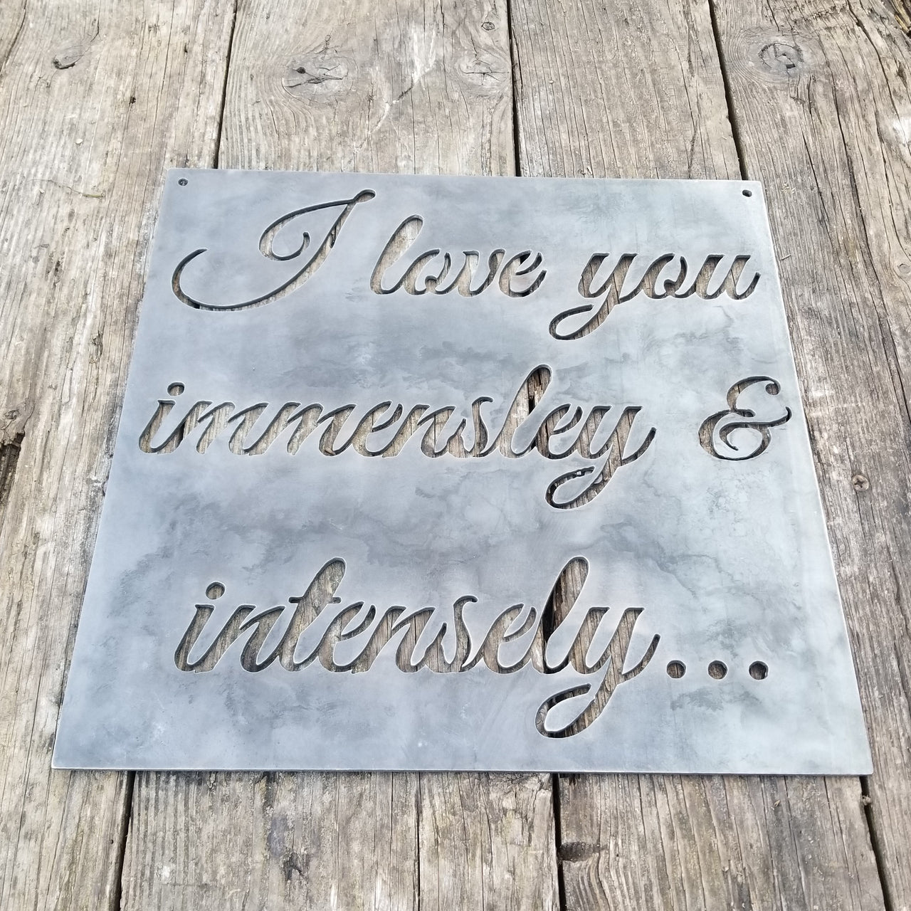 Square plaque with cursive writing in it. The sign reads, " I Love you immensely and intensely"