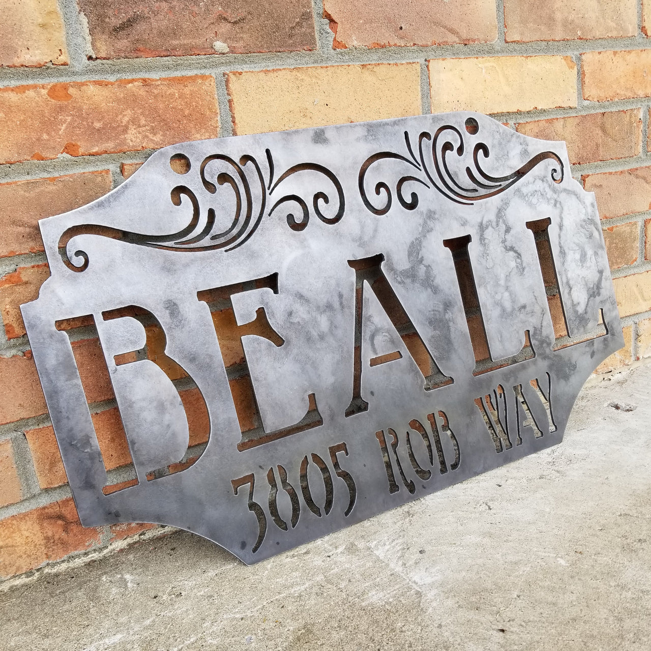 This custom metal address sign is raw steel and reads, "Beall 385 Rob Way"