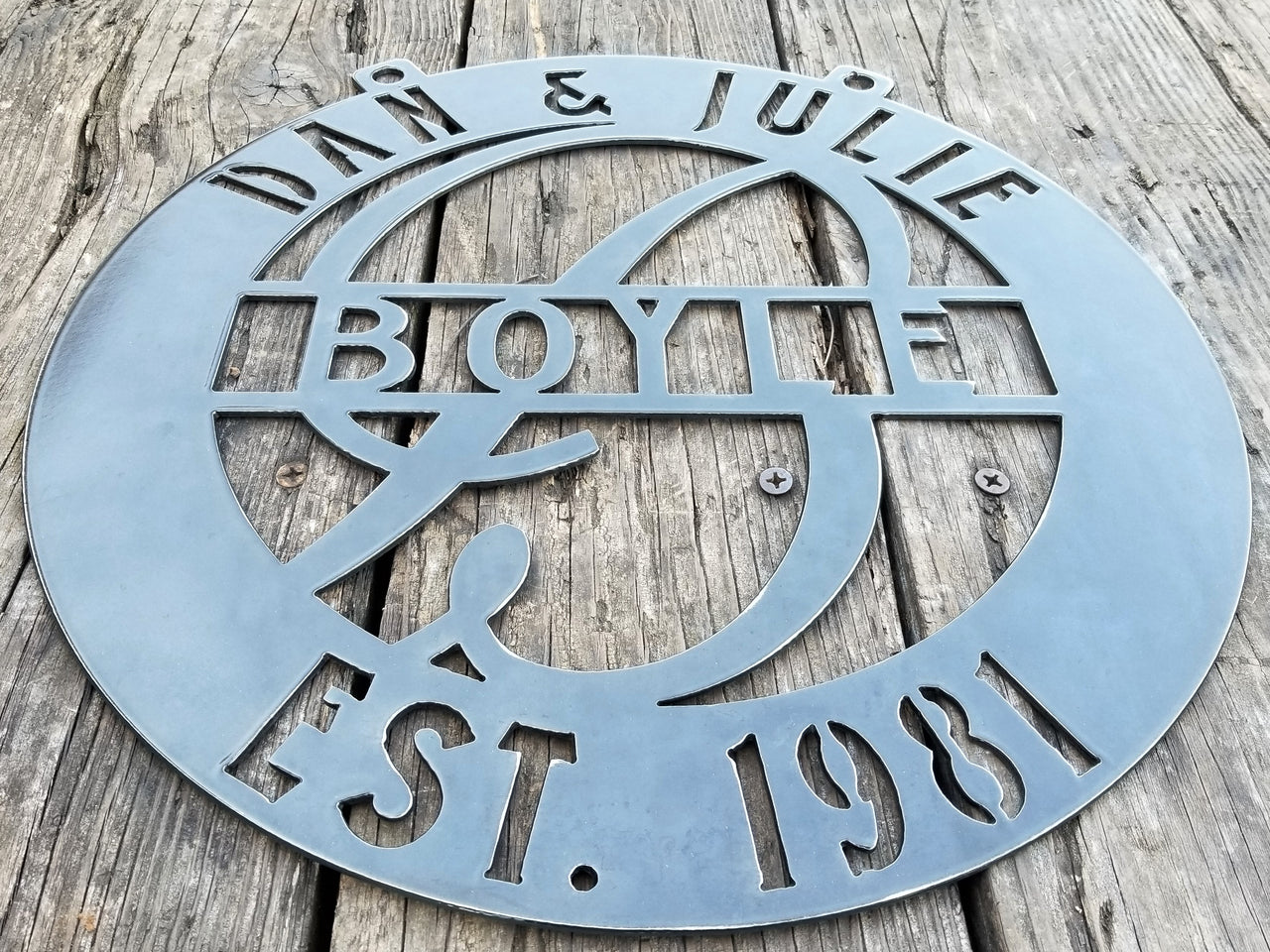 This is a round metal monogram with 1/2" dog ears for hanging that reads, " Dan & Julie, Boyle, Established 1981"