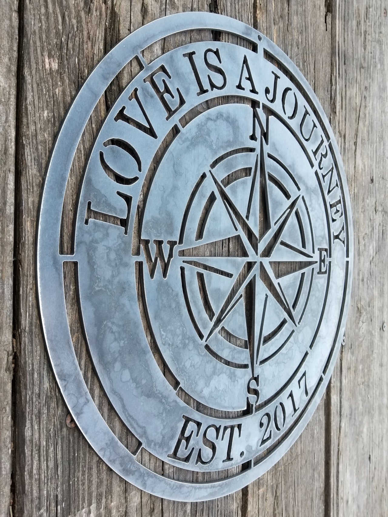 A nautical compass rose which reads, "Love is A Journey".