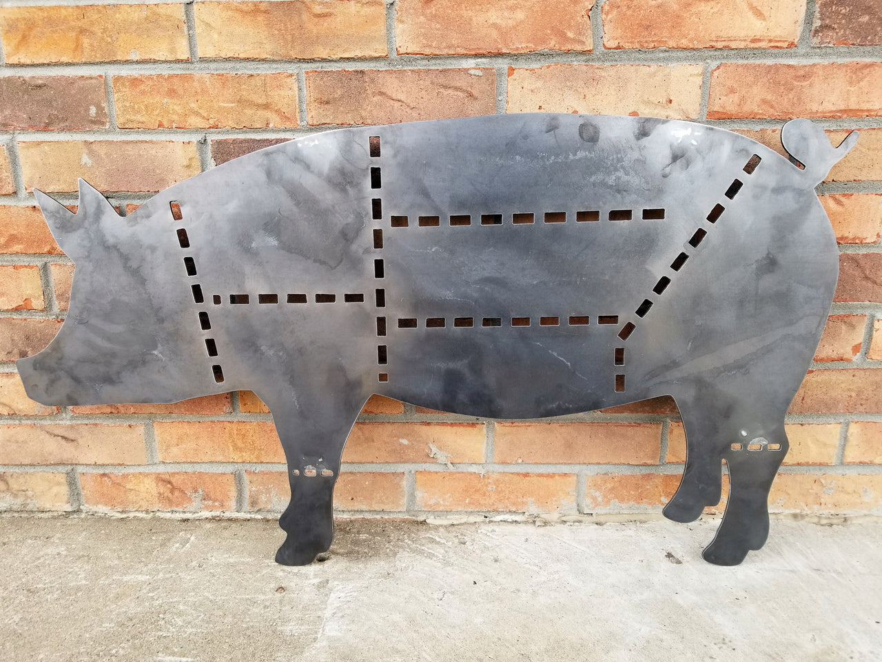 This sign is in the shape of a pig and dotted lines separate the cuts of pork
