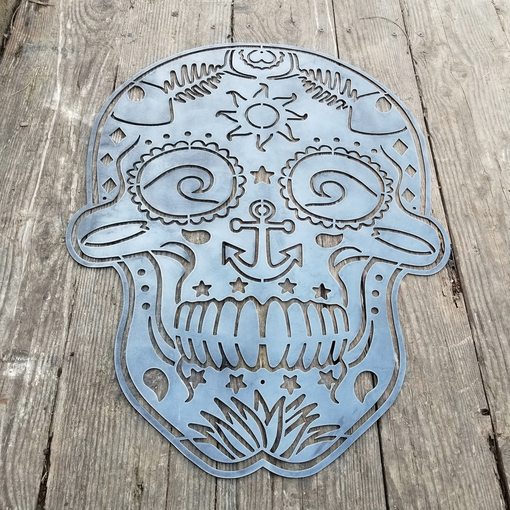 This sign is in the shape of a sugar skull. It is water themed with waves, fish bones, anchors and more.