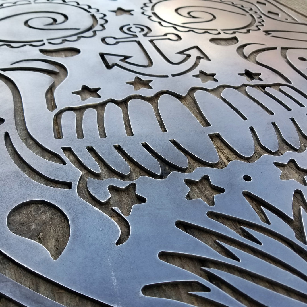 This sign is in the shape of a sugar skull. It is water themed with waves, fish bones, anchors and more.