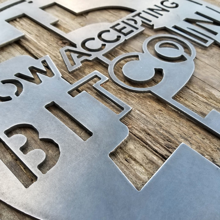 This is a round sign that reads, "Now Accepting Bitcoin".