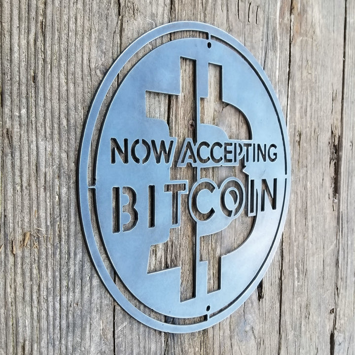 This is a round sign that reads, "Now Accepting Bitcoin".