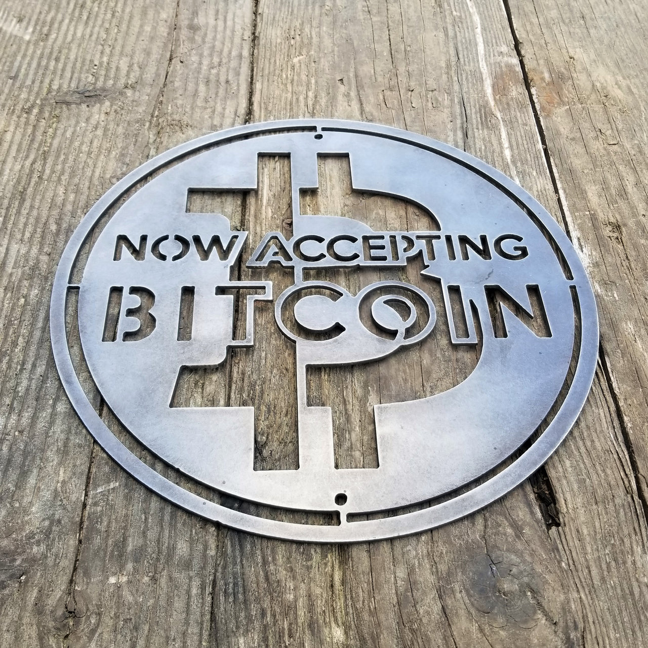 This is a round sign that reads, "Now Accepting Bitcoin".
