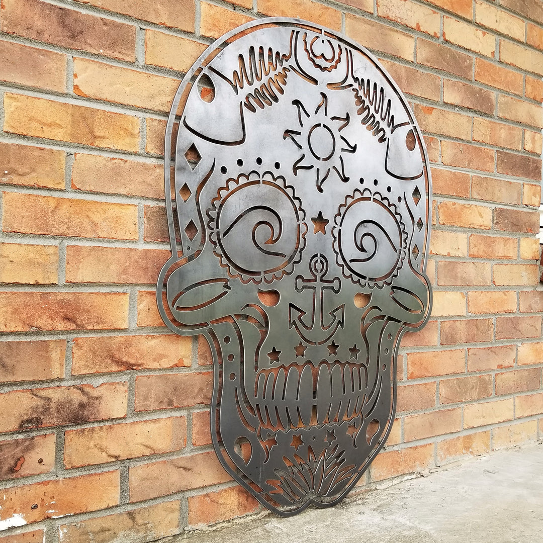 This sign is in the shape of a sugar skull. It is water themed with waves, fish bones, anchors and more.