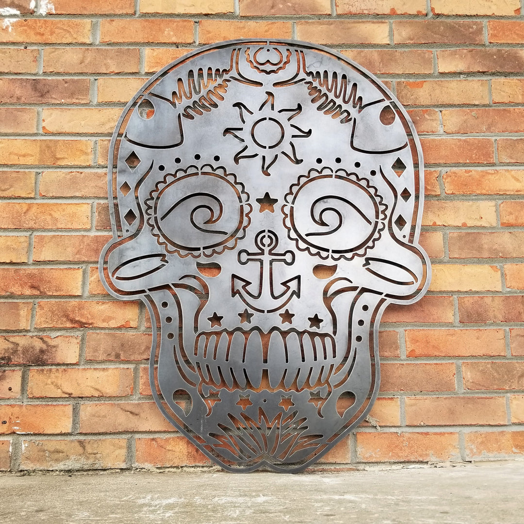 This sign is in the shape of a sugar skull. It is water themed with waves, fish bones, anchors and more.