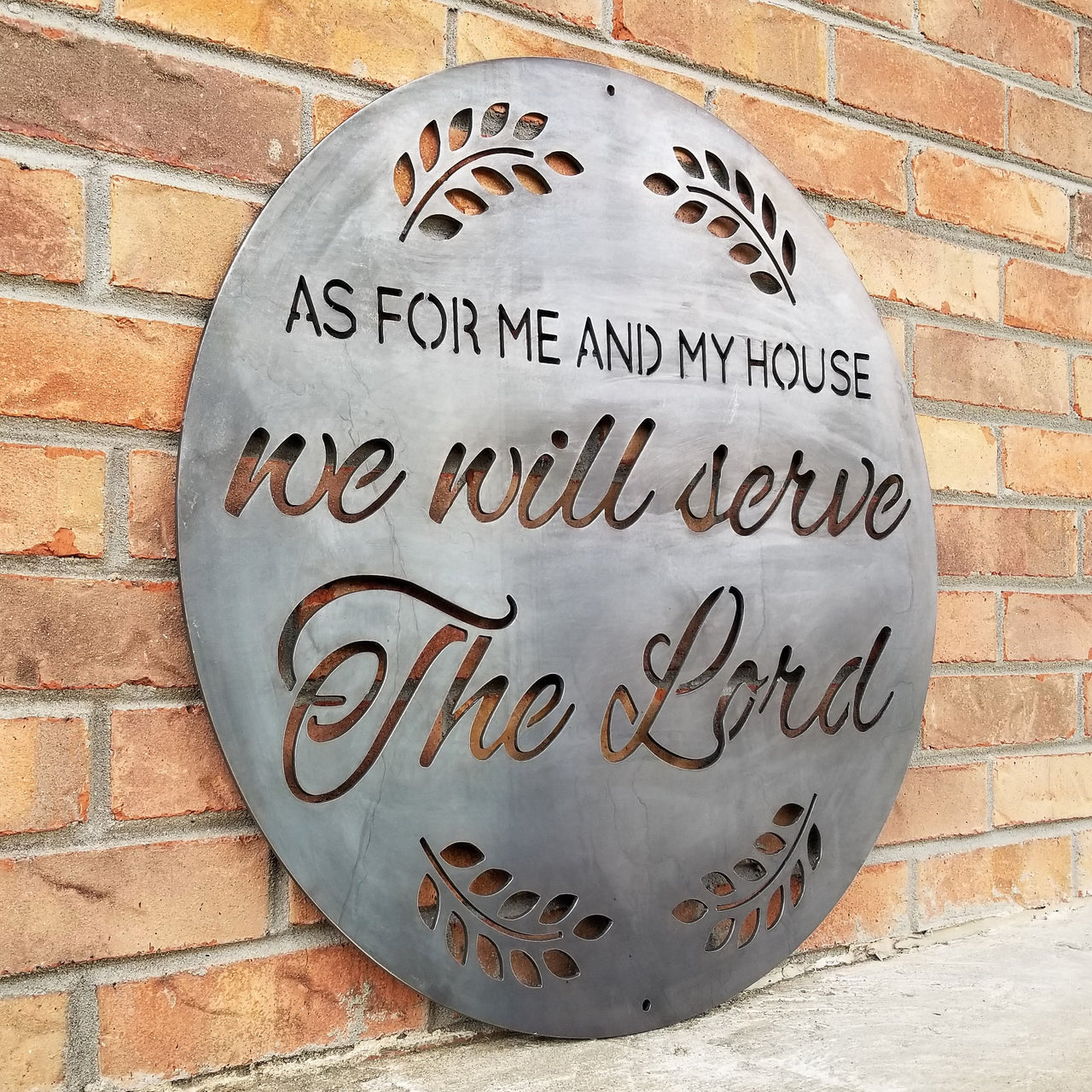 A round sign that reads, " As For Me and My House, We Will Serve the Lord".
