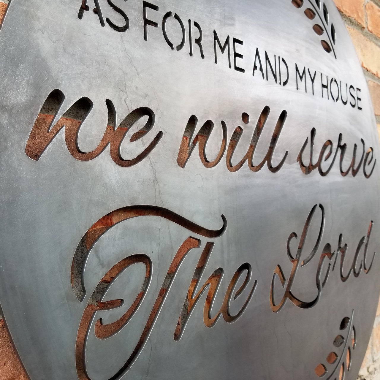 A round sign that reads, " As For Me and My House, We Will Serve the Lord".