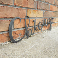 Thumbnail for This metal home decor is in the shape of a cursive word and reads, 