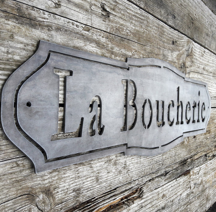 French country, raw steel, metal sign which reads, "La Boucherie"