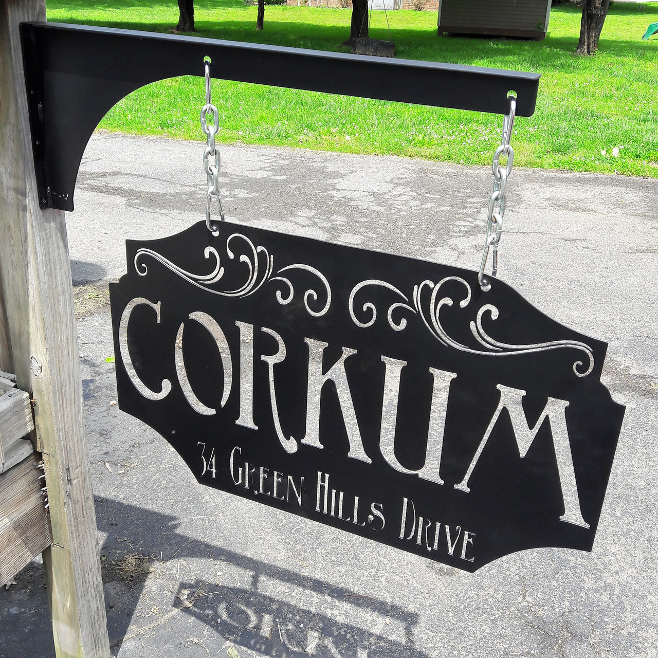 This custom metal sign is Powdercoated and comes with a matching hanging post, silver chain and carabiners. The hanging sign reads, "Corkum in Green Hills Drive". it is an address sign