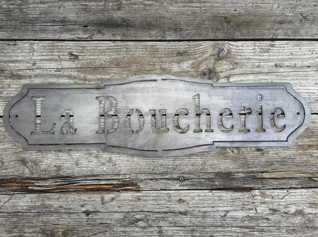 French country, raw steel, metal sign which reads, "La Boucherie"