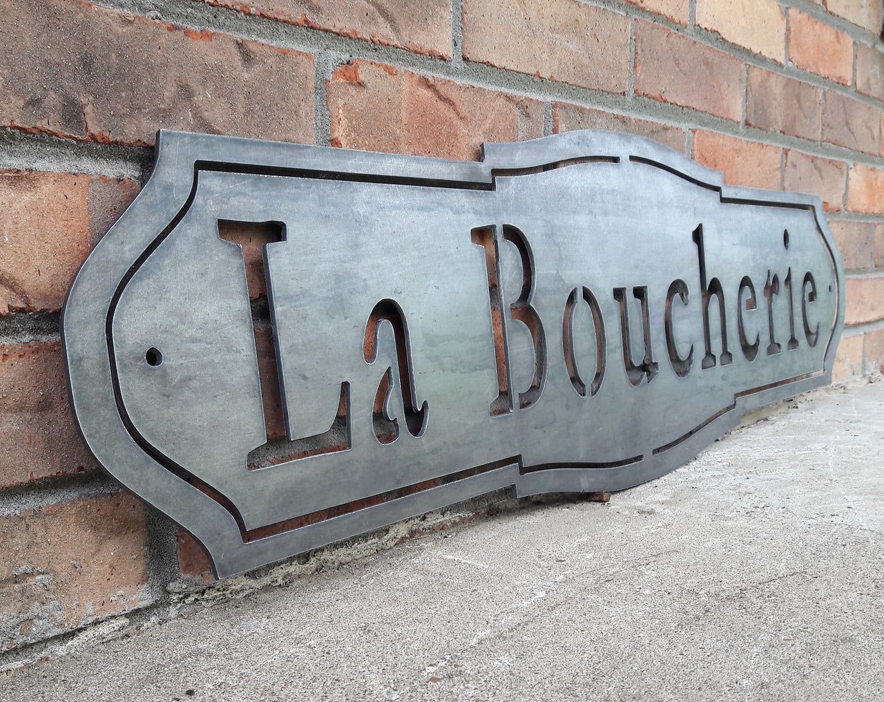 French country, raw steel, metal sign which reads, "La Boucherie"
