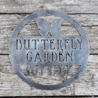 Thumbnail for Round metal sign with the image of a Butterfly at the top and three lines of text. The sign reads, 